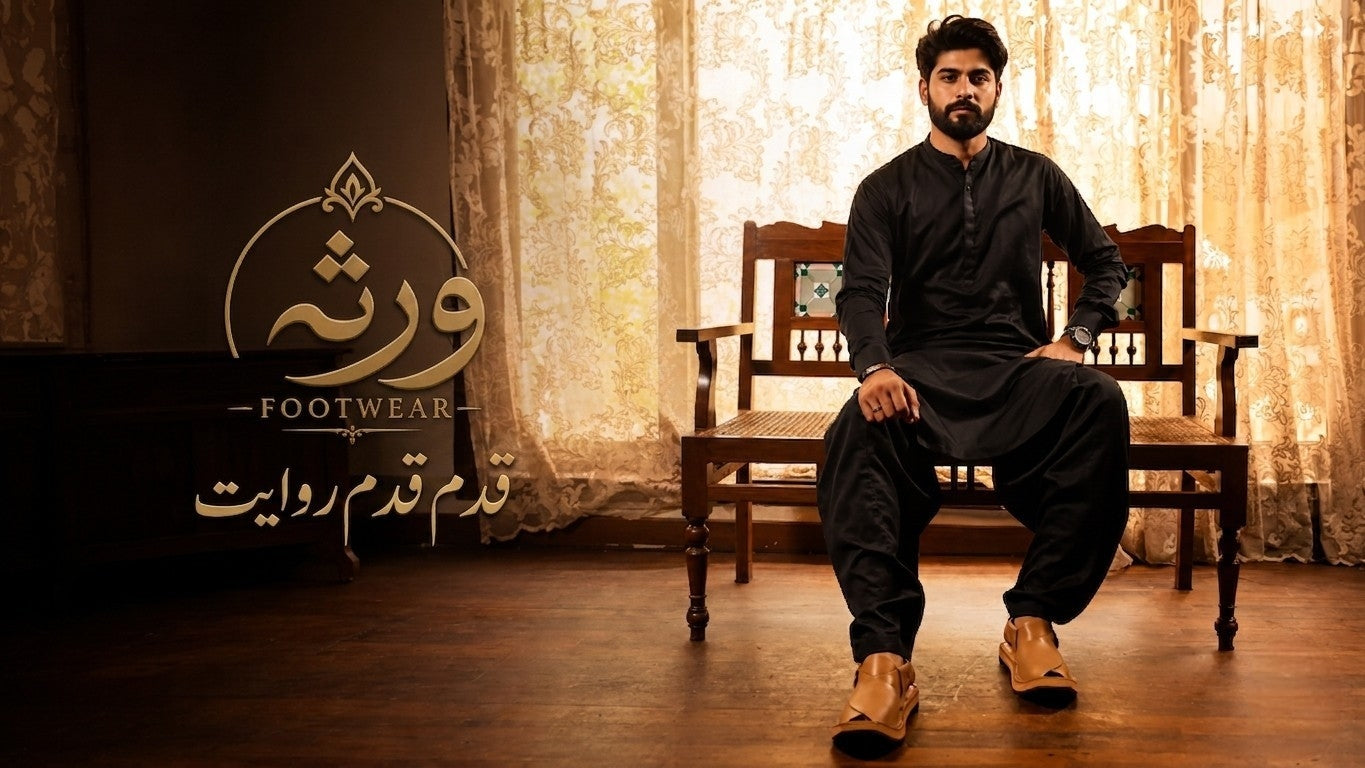 Man sitting on a chair wearing black shoes with 'Footwear' brand logo in the background.